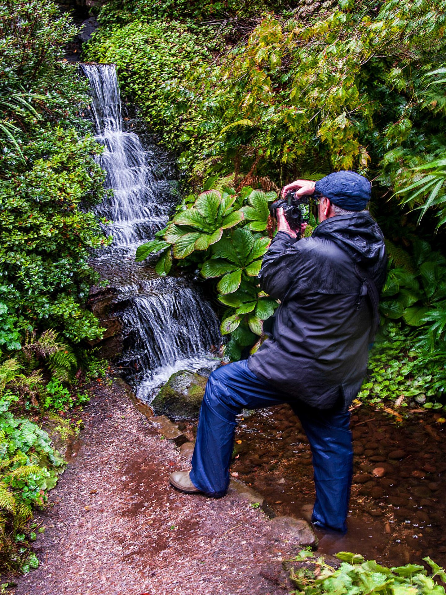 Man taking photo of waterfall